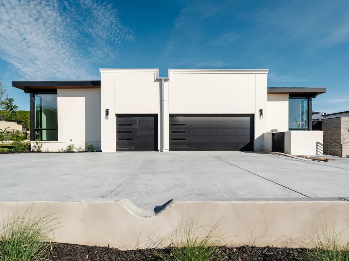 Two contemporary homes with garages and concrete driveways