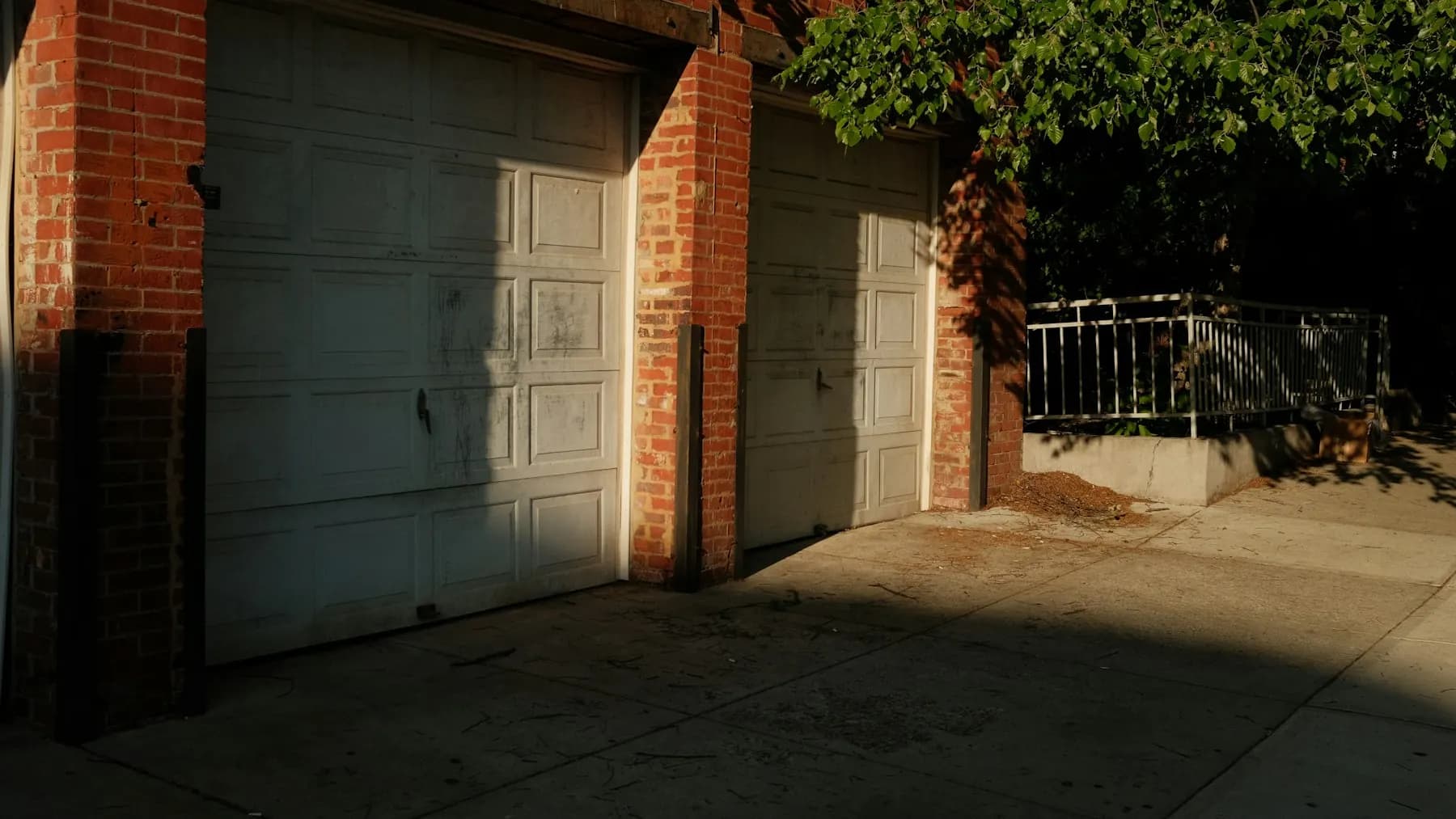 Concrete slab and apron in front of two brick garages