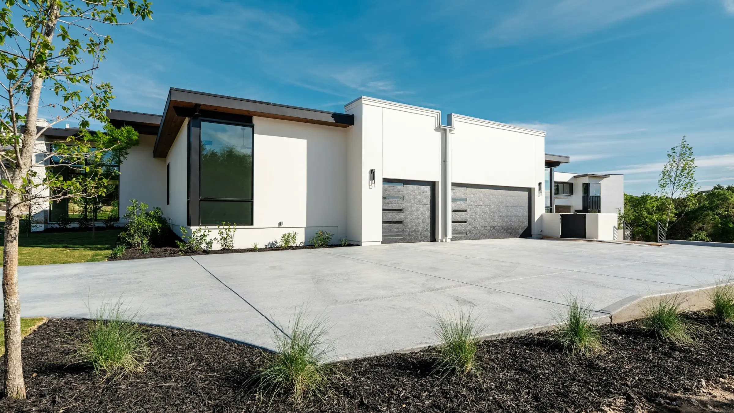 House with two garage doors and a wide concrete driveway