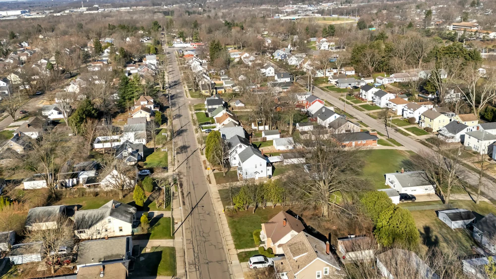 Wide view of a residential street lined with concrete driveways