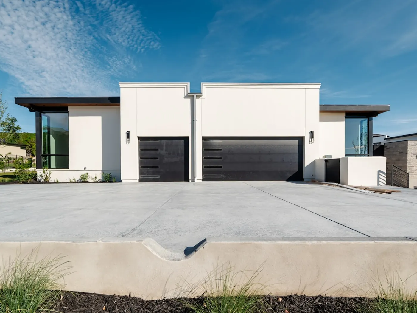 Two contemporary homes with garages and concrete driveways