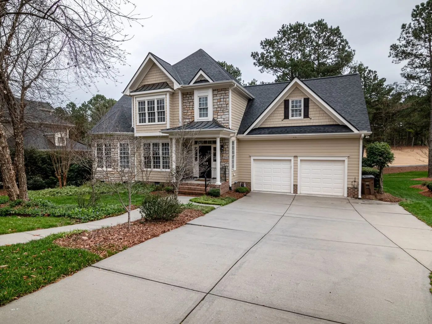 Two-storey home with a wide concrete driveway leading to a two-car garage