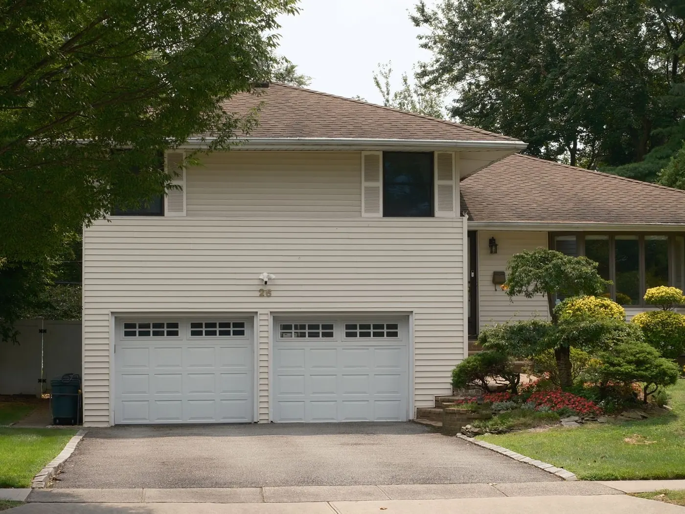 Two garage doors above a concrete apron and driveway
