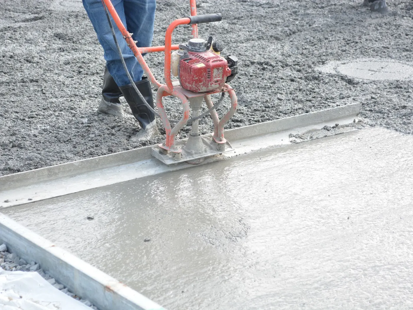 Power screed levelling a freshly poured concrete slab