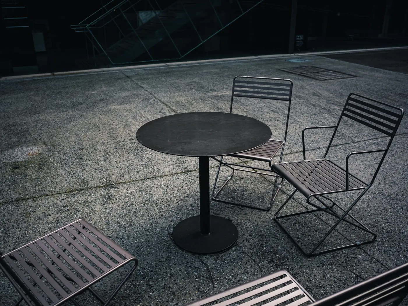 Table and chairs on a grey concrete patio