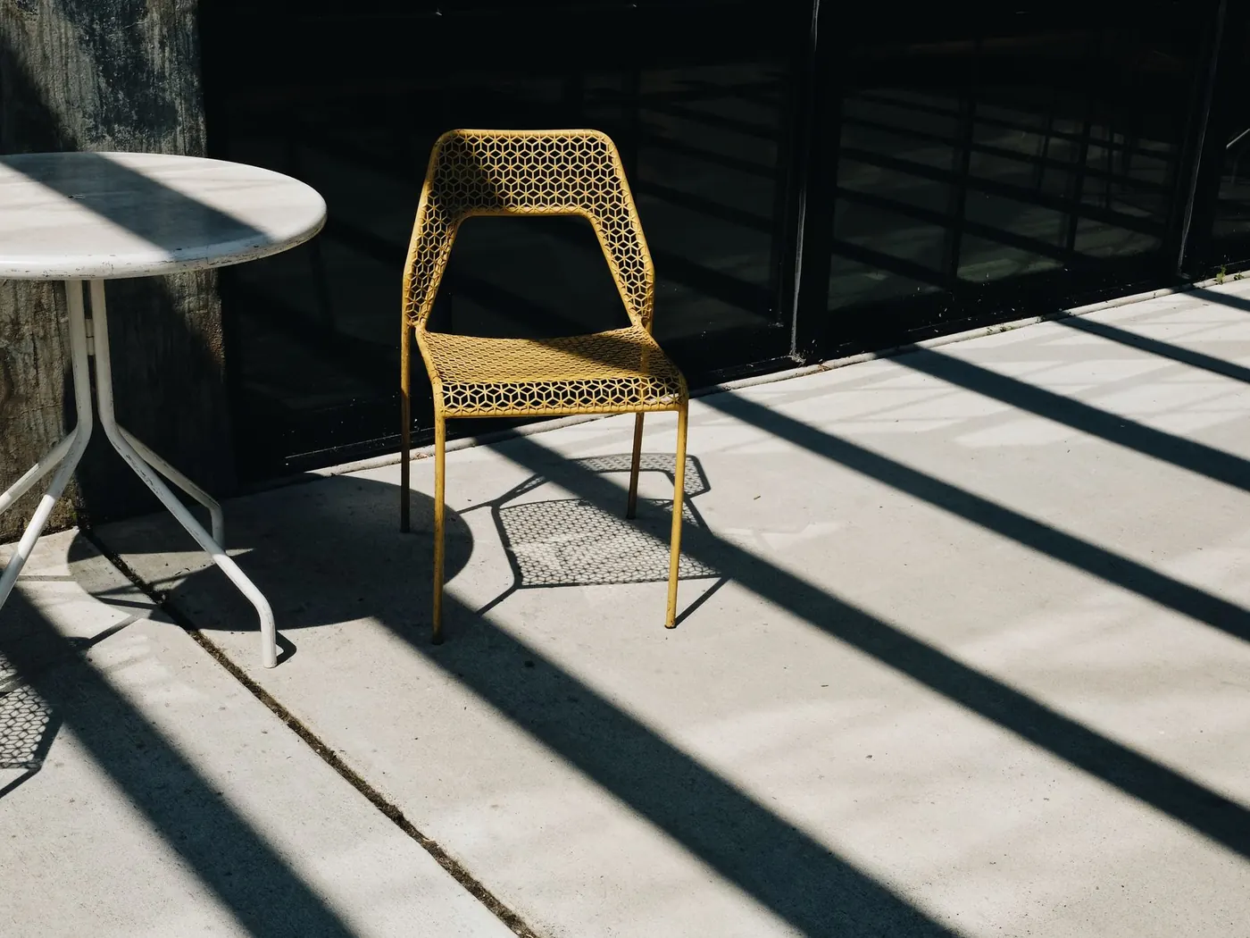 Patio chair and table on a sunlit concrete slab