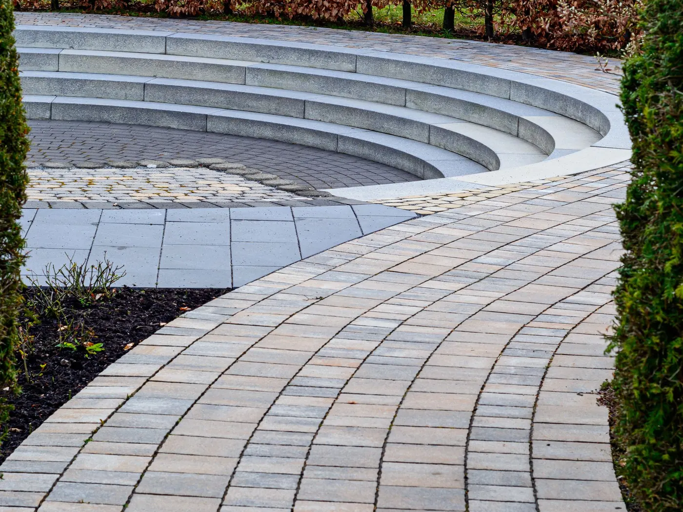 Curved decorative paving leading to a set of radial steps
